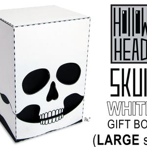 May include: White cardboard gift box shaped like a skull with a black and white design. The box is labeled "Hollow Head Skull White Gift Box (Large Size)"