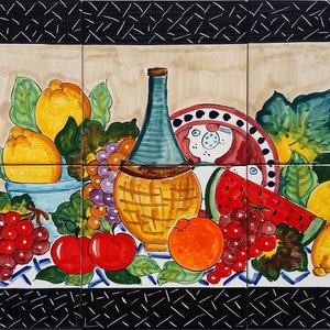 Op de afbeelding: Een kleurrijk stilleven met fruit en een fles wijn. Het schilderij toont citroenen, druiven, een watermeloen, sinaasappels en appels. De fles wijn bevindt zich in een rieten mand. Het schilderij is op een betegelde achtergrond met een zwarte rand.