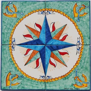 Peut inclure: Un carreau de céramique peint à la main avec un motif de rose des vents. La rose des vents est bleue, orange, rouge et verte. Le carreau est entouré d'un motif de corde jaune avec des ancres à chaque coin. Le carreau est étiqueté avec les mots "Nord", "Est", "Sud" et "Ouest".