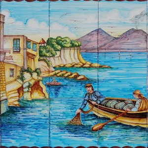 May include: A hand-painted ceramic tile depicting a colorful scene of a small Italian village with a mountain in the background. Two people are fishing in a boat in the foreground. The tile is signed "MARECHIARO".