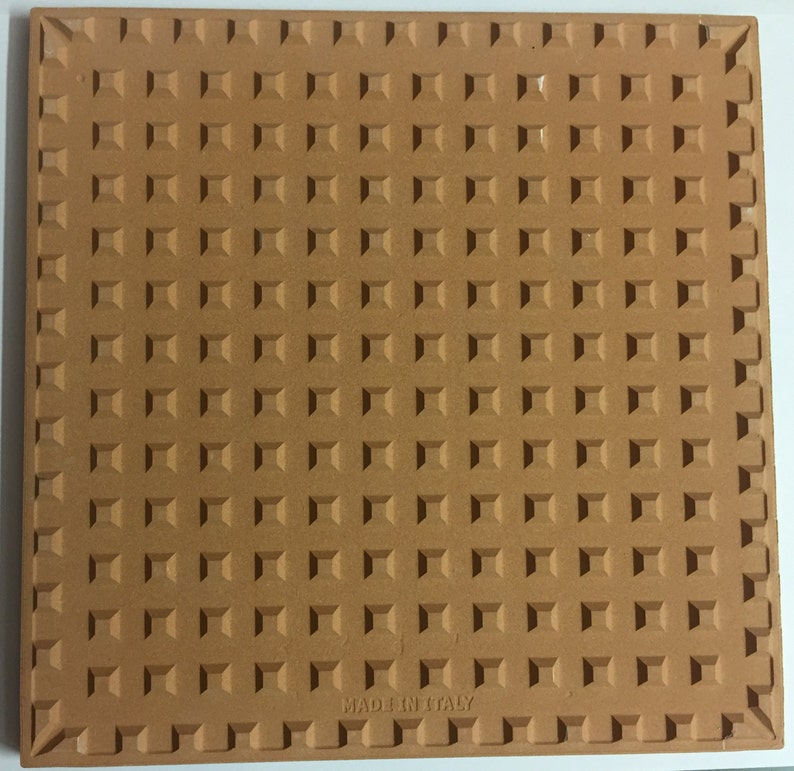 K&ouml;nnte beinhalten: Eine Terrakotta-Fliese mit einer strukturierten Oberfl&auml;che und dem Aufdruck "Made in Italy" auf der Unterseite.