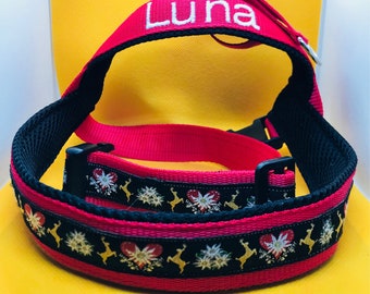 May include: Red and black dog harness with a white embroidered name "Luna" and a traditional alpine pattern with hearts and deer.