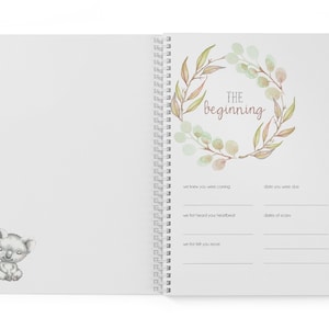 May include: A white journal with a watercolor wreath of leaves and the text "THE beginning" in pink. The journal has a spiral binding and a koala illustration on the left page.
