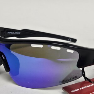 K&ouml;nnte beinhalten: Schwarze Rawlings-Sonnenbrille mit blau verspiegelten Gl&auml;sern. Die Sonnenbrille hat ein sportliches Design mit einem umlaufenden Rahmen. Das Rawlings-Logo ist auf dem Rahmen und den Gl&auml;sern sichtbar. Ein Etikett mit "HIGH PERFORMANCE SUNGL" ist angebracht.