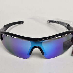 K&ouml;nnte beinhalten: Schwarze Sportsonnenbrille mit blau und violett verspiegelten Gl&auml;sern. Die Sonnenbrille hat einen schwarzen Rahmen und ein angebrachtes Etikett. Die Gl&auml;ser haben eine gebogene Form und sind so konzipiert, dass sie die Augen umschlie&szlig;en.
