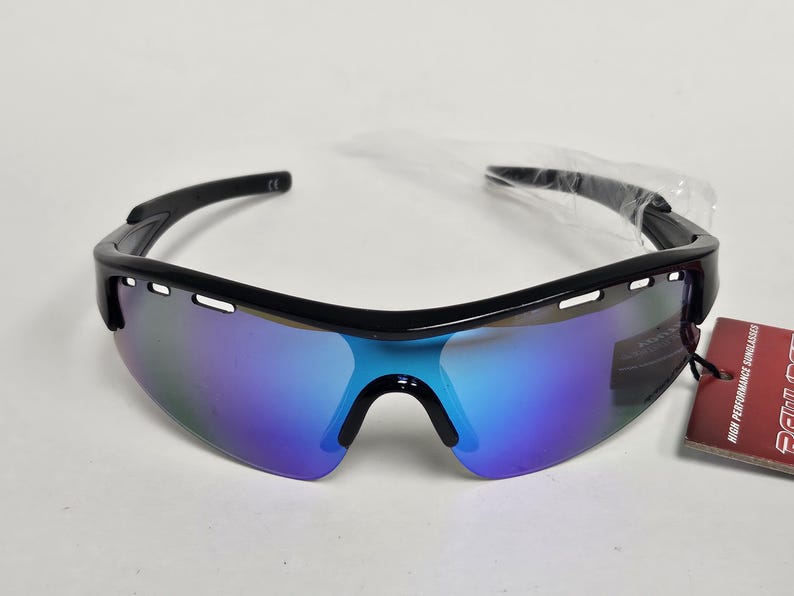 K&ouml;nnte beinhalten: Schwarze Sportsonnenbrille mit blau und violett verspiegelten Gl&auml;sern. Die Sonnenbrille hat einen schwarzen Rahmen und ein angebrachtes Etikett. Die Gl&auml;ser haben eine gebogene Form und sind so konzipiert, dass sie die Augen umschlie&szlig;en.