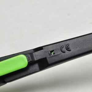 May include: Close-up of a black and green pair of glasses with a CE marking on the side.