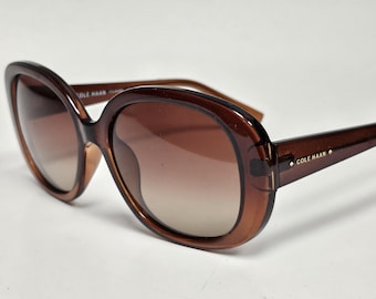Gafas de sol polarizadas ovaladas con diseño envolvente de Cole Haan, color marrón degradado.