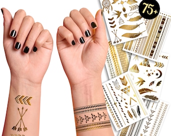 May include: A set of 75+ gold temporary tattoos featuring various designs, including arrows, feathers, geometric shapes, and dreamcatchers. The tattoos are shown applied to a person's wrist and forearm.
