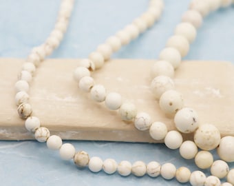 Strand of natural magnesite beads creamy white-brown marbled selection