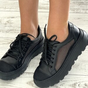 May include: Black sneakers with a mesh panel and a chunky platform sole.