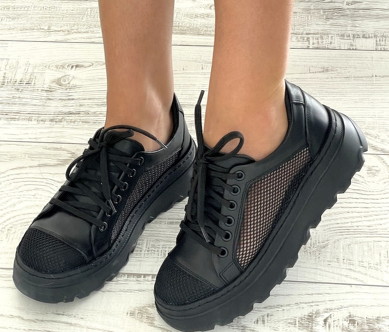 May include: Black sneakers with a mesh panel and a chunky platform sole.