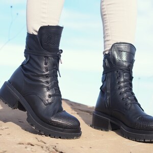 K&ouml;nnte beinhalten: Schwarze Schn&uuml;rstiefeletten aus Leder mit einem dicken Absatz und einem strukturierten Muster an der Spitze.