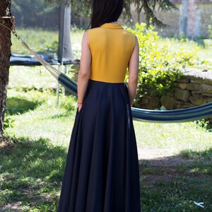 May include: A sleeveless maxi dress with a yellow bodice and a black skirt. The dress has a collared neckline and a fitted bodice.