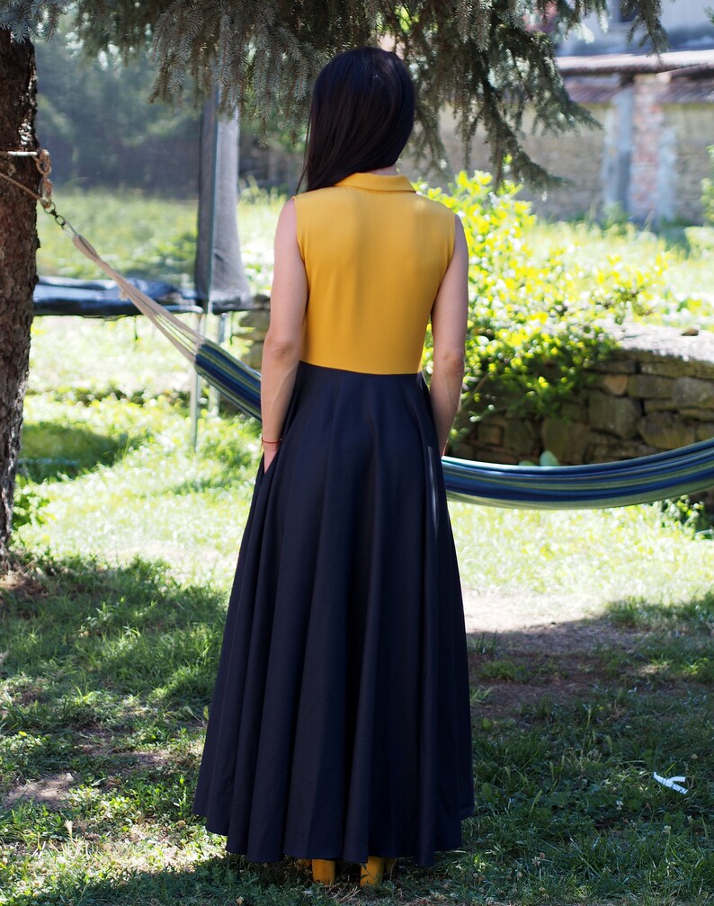 May include: A sleeveless maxi dress with a yellow bodice and a black skirt. The dress has a collared neckline and a fitted bodice.