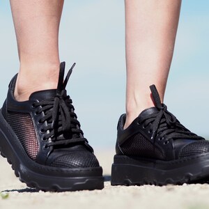 May include: A pair of black sneakers with mesh panels and a chunky platform sole.