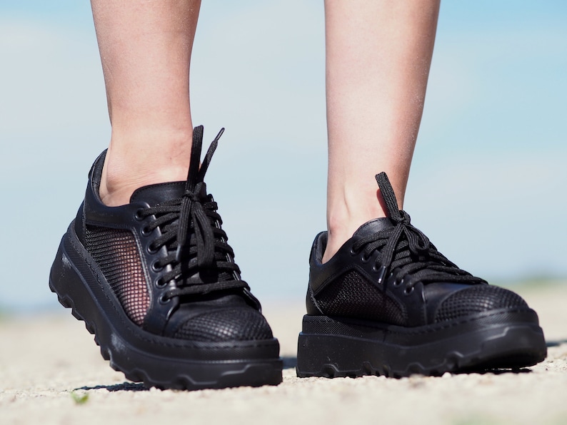 May include: A pair of black sneakers with mesh panels and a chunky platform sole.