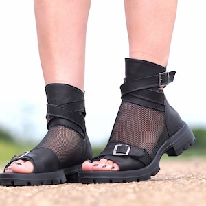 K&ouml;nnte beinhalten: Schwarze Ledersandalen mit einem Mesh-Einsatz und Schnallenverschluss. Die Sandalen haben eine dicke Plateau-Sohle.