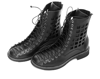 May include: A pair of black leather ankle boots with cutouts and lace-up fastenings. The boots have a chunky heel and a rounded toe.