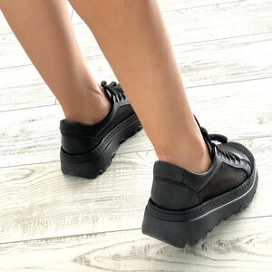 May include: Black platform sneakers with mesh panels and a chunky sole.