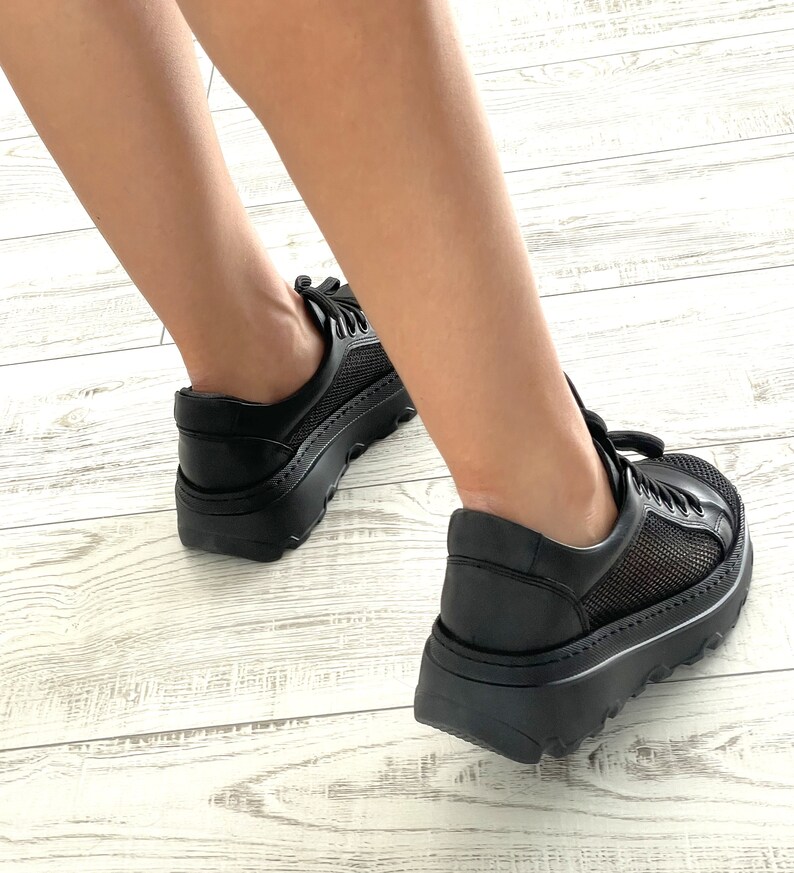 May include: Black platform sneakers with mesh panels and a chunky sole.