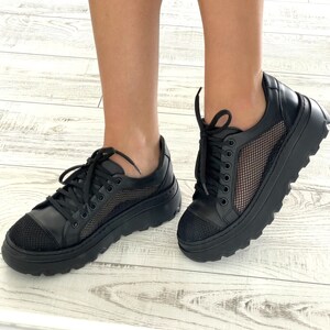May include: Black sneakers with a mesh panel and a thick platform sole.