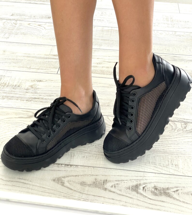 May include: Black sneakers with a mesh panel and a thick platform sole.