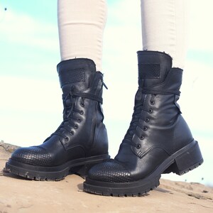 K&ouml;nnte beinhalten: Schwarze Leder-Stiefeletten mit Schn&uuml;rung und einem dicken Absatz. Die Stiefeletten haben ein strukturiertes Muster an der Spitze und einen Rei&szlig;verschluss an der Seite.