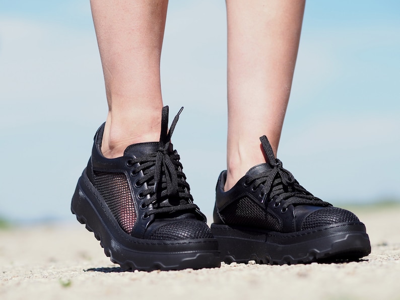 May include: A pair of black leather sneakers with mesh panels and a chunky platform sole.