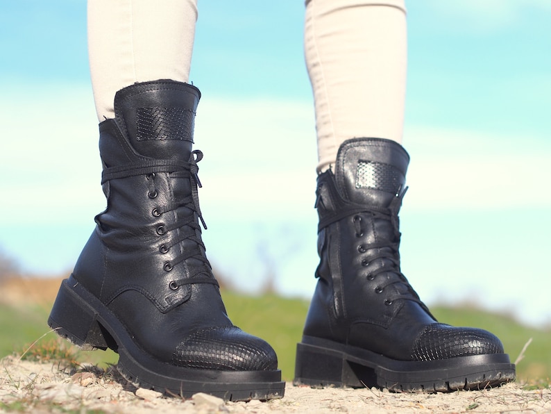 K&ouml;nnte beinhalten: Schwarze Schn&uuml;rstiefeletten aus Leder mit einem dicken Absatz und einem Schlangenhautmuster an der Spitze.