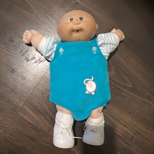 Muñeca Cabbage Patch Kids vintage de 1978-1982, recién nacida, calva, con ojos marrones y hoyuelos.