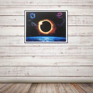 Könnte beinhalten: Ein gerahmter Druck einer Sonnenfinsternis mit einem dunkelblauen, violetten und orangefarbenen Himmel. Die Sonnenfinsternis ist von einem leuchtend orangefarbenen Ring umgeben und ein dunkelblauer Planet ist im Vordergrund zu sehen.