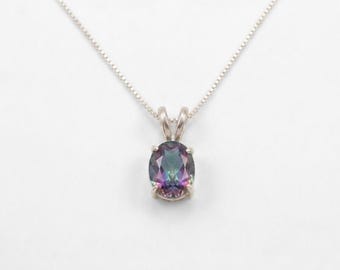May include: A silver necklace with a pendant featuring an oval-cut, iridescent gemstone. The gemstone displays a range of colors, including purple, green, and blue. The chain is delicate and the pendant is centered.
