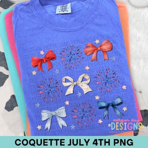 Könnte beinhalten: Ein Stapel bunter T-Shirts. Das oberste Shirt ist blau mit einem Design aus roten, weißen und blauen Schleifen, Feuerwerk und Sternen. Der Text "COQUETTE JULY 4TH PNG" steht unten. Der Markenname "morgan day DESIGNS" befindet sich unten rechts.
