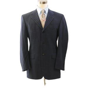 May include: A dark navy blue pinstripe suit jacket with a light blue dress shirt and patterned tie. The jacket has a three-button closure, notched lapels, and two front pockets. The suit is displayed on a mannequin.