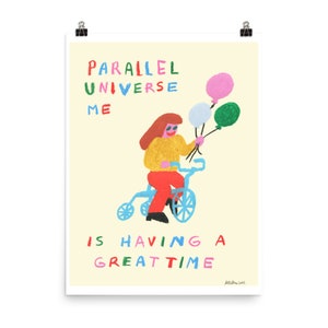 May include: A yellow and red illustration of a person riding a blue tricycle with three balloons. The text "PARALLEL UNIVERSE ME IS HAVING A GREAT TIME" is written in colorful letters.