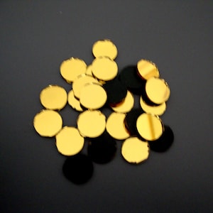 May include: A pile of round, gold-coloured, decorative mirror tiles.