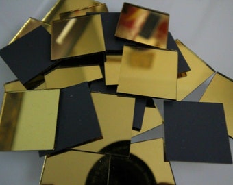 May include: A pile of small, square, gold-colored mirror tiles. The tiles are arranged in a random pattern and some are overlapping.