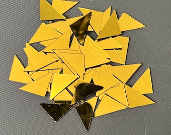 May include: A pile of gold-colored triangular mirror tiles.