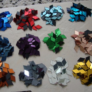 May include: Assortment of 12 piles of small, diamond-shaped mirror tiles in various colors, including red, blue, green, purple, gold, silver, and copper.