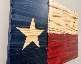 May include: A wooden Texas flag with a blue, white, and red color scheme. The star is made of natural wood and the flag is distressed.