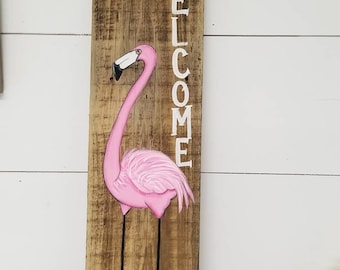 Welcome flamingo painted on aged wood.