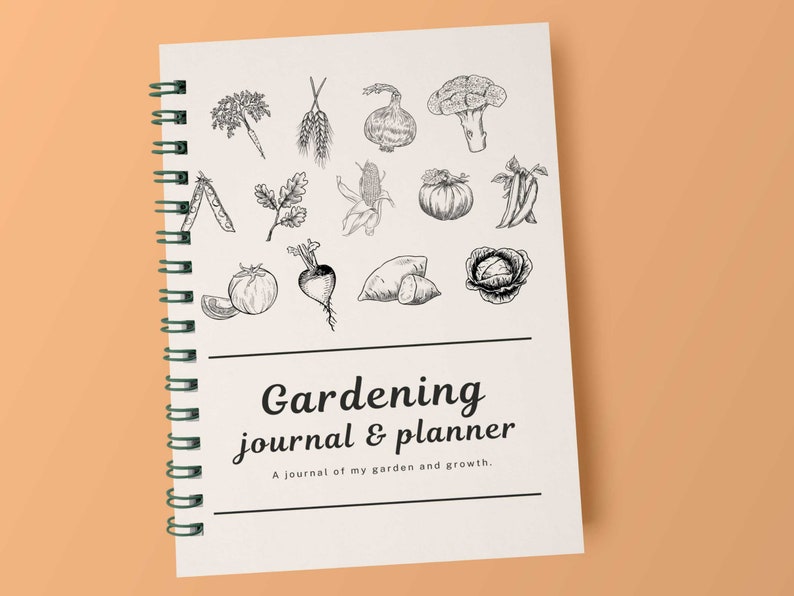 Puede incluir: Un diario y planificador de jardiner&iacute;a con espiral y cubierta crema. La cubierta presenta ilustraciones detalladas en blanco y negro de varias verduras y el texto "Gardening journal & planner". El texto de abajo dice "A journal of my garden and growth."