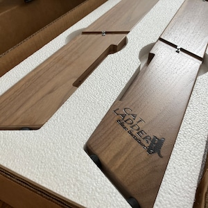 May include: Two wooden cat ladders in a brown cardboard box with white foam padding. The ladder on the right has the text "CAT LADDER" and "Elite Furniture" engraved on it.