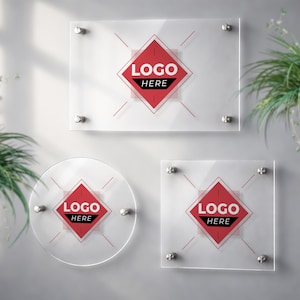 May include: Three clear acrylic signs in rectangular, circular, and square shapes. Each sign features a red diamond logo with the text "LOGO HERE" in white. The signs are mounted with silver hardware.