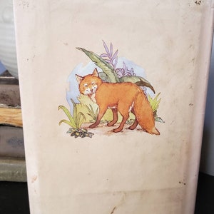 May include: The back cover of a children's book featuring a cartoon fox in a forest setting. The book's ISBN is 0-87614-235-2.