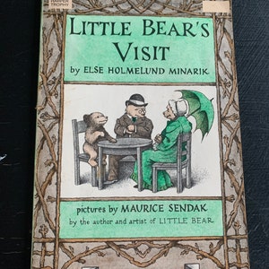 May include: A vintage children's book cover with a green background and a brown border. The title is "Little Bear's Visit" by Else Holmelund Minarik. The book cover features an illustration of three bears sitting at a table with a green umbrella in the background. The text "An I Can Read Book" is at the bottom of the cover.