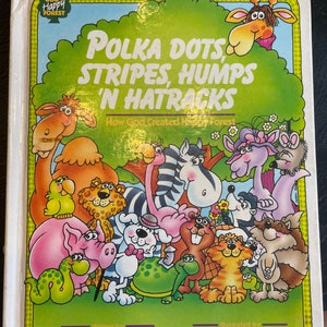 May include: A children's book cover with a green background and a title that reads "Polka Dots, Stripes, Humps 'N Hatracks." The subtitle reads "How God Created Happy Forest." The cover features illustrations of various animals, including a giraffe, zebra, camel, pig, and turtle.
