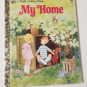 May include: A Little Golden Book titled "My Home" with a colorful illustration of a girl and boy standing outside a wooden house. The house is surrounded by green trees and flowers. A small dog and a doll are also in the scene.