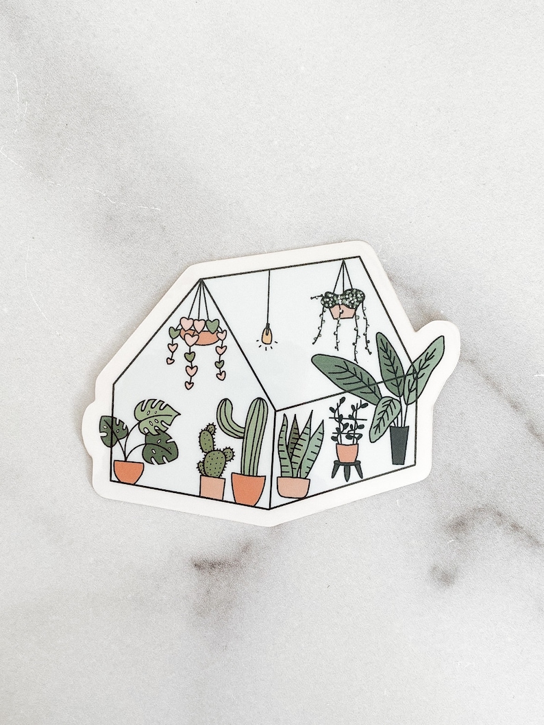 May include: A sticker of a greenhouse with a variety of plants, including cacti, succulents, and leafy plants. The greenhouse is decorated with pink hearts and a light bulb.